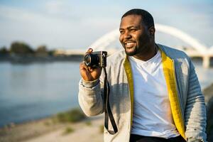 moderno negro hombre disfruta fotografiando paisaje urbano foto