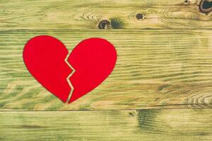 Broken heart on a wooden background photo