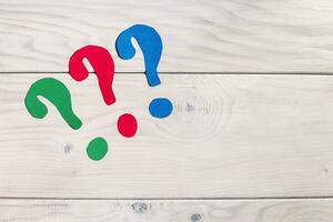 Colorful question marks on a wooden table photo