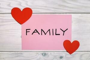 Family concept with red hearts on wooden background photo