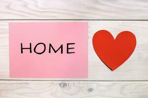 hogar concepto con corazón y rojo papel en de madera antecedentes foto