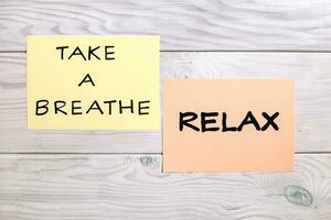 Text take a breath and relax on wooden table photo