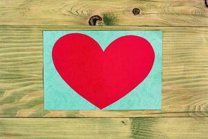 Red heart on a wooden background photo