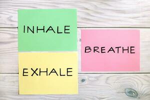 Words inhale,exhale and breath on wooden table photo