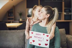 Happy mother and  daughter with  heart shapes and text on greeting card.  Mother's day concept. photo