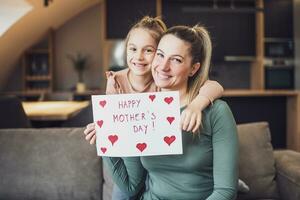 Happy mother and  daughter with  heart shapes and text on greeting card.  Mother's day concept. photo