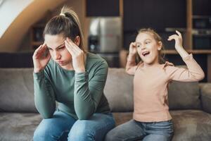 Stressed mother is feeling desperate because of screaming her daughter photo