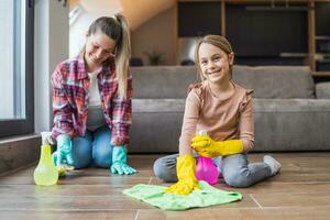 Happy daughter and mother cleaning house together photo