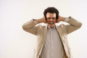 Image of frustrated businessman is covering his ears and shouting. photo