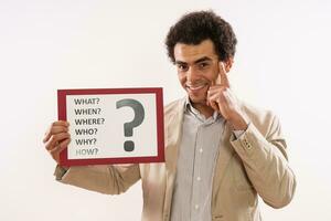 Image of  businessman holding paper with  question mark and various questions photo