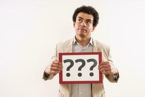 Image of confused businessman  showing paper with question marks photo