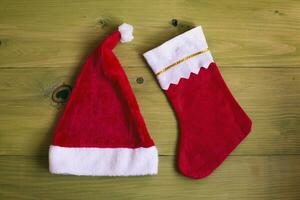 Image of Santa Hat and Christmas stocking on wooden table photo
