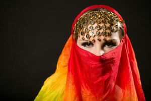 Close up portrait of belly dancer wrapped in veil photo