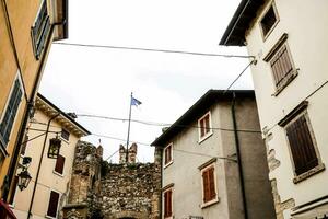 a narrow street with buildings and a flag on top photo