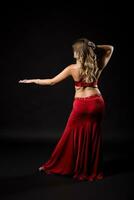 Belly dancer performing belly dance on black background photo