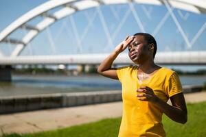 Exhausted woman drinking energy drink after exercise photo