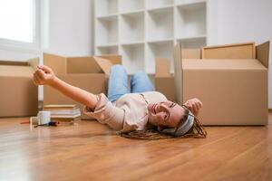 Happy ginger woman with braids moving into new apartment. photo