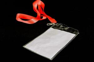 a blank white card with red lanyard on a black background photo