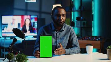 Tech content creator filming green screen tablet unboxing, giving reasons to purchase it. Influencer recording video urging subscribers to buy sponsoring partner mockup digital device