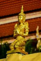 a golden buddha statue is on top of a building photo