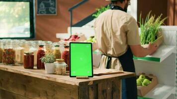 groene scherm Aan tablet in de buurt cliënt controle bulk producten opgeslagen in herbruikbaar potten, klanten ondersteunen niet-vervuilend levensstijl in lokaal supermarkt. geïsoleerd Chroma sleutel sjabloon Aan mobiel apparaat. video