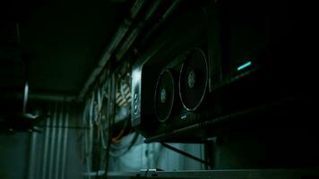 A dark concrete interior with a ceiling fan and multiple wires hanging from it video