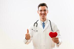 Portrait of doctor with stethoscope showing heart shape and thumb up photo