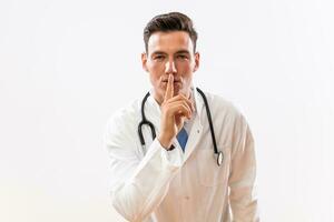 Portrait of doctor showing silence sign photo