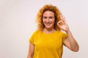Beautiful and happy ginger woman showing ok sign photo