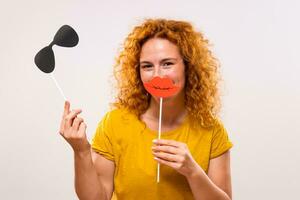 Happy ginger woman is having fun with party props photo