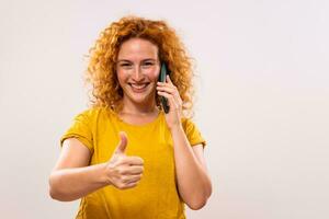 Image of happy ginger woman talking on the phone and showing thumb up photo