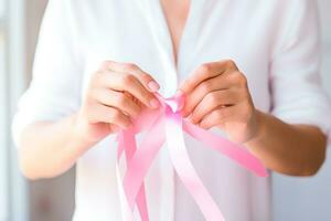 Pink October - Dedicated woman, lovingly weaving a pink ribbon, a symbol of awareness for the early detection of breast cancer. Together, we are stronger. We will beat breast cancer. AI Generative photo