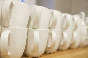 lots of white clean coffee cups after washing in the dishwasher stand in a row. selective focus.High quality photo