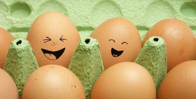 Emotional chicken eggs in a tray. Different grimaces drawn on chicken eggs. High quality photo