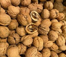 walnuts in large quantities in the skin and one nut chopped. selective focus photo