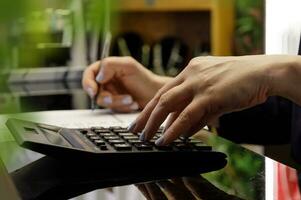 hands of women who count the estimate on the calculator and record the data. selective focus.High quality photo
