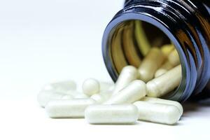 capsules with the drug are poured out of a glass bottle. selective focus. High quality photo