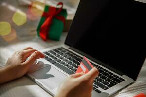 girl enters credit card details into laptop while shopping. selective focus photo