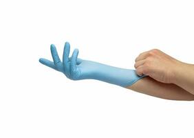 hand puts on blue disposable medical gloves isolated on white background. Infection control concept. photo