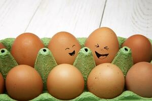 Emotional chicken eggs in a tray. Different grimaces drawn on chicken eggs. High quality photo