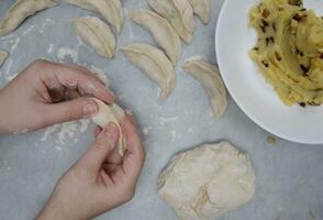 the hands of a child who learns to make dumplings with potatoes. selective focus. photo