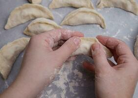 the hands of a child who learns to make dumplings with potatoes. selective focus. photo