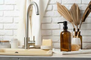 Recycled plastic pump bottle for mockup on white brick wall background near sink photo