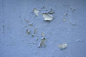 White peeling paint wall surface with moldy.Weathered concrete pattern wall.Old white color painted peeling off moment to do can see raw concrete texture wall.Swelling concrete wall texture. photo