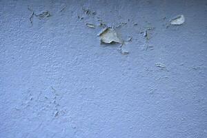 White peeling paint wall surface with moldy.Weathered concrete pattern wall.Old white color painted peeling off moment to do can see raw concrete texture wall.Swelling concrete wall texture. photo