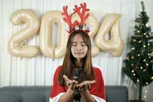 Asian women dress up as shanties to make wishes in anticipation of Christmas 2024. Rooms are decorated with Christmas trees and 2024 balloons. photo