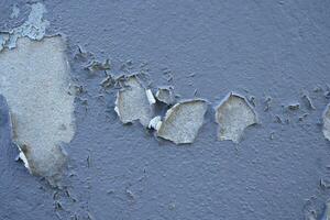 Old cement Wall Peel exterior Background with blue Paint peeling low quality, Cracked Wall photo