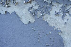 White peeling paint wall surface with moldy.Weathered concrete pattern wall.Old white color painted peeling off moment to do can see raw concrete texture wall.Swelling concrete wall texture. photo