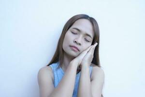 Asian woman is sleepy leaning against a wall photo