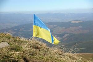 Ukrainian flag on top of Hoverla mountain in Ukraine photo